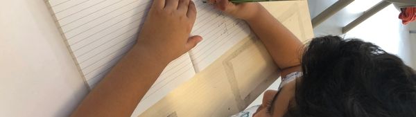 Child writing in notebook at school