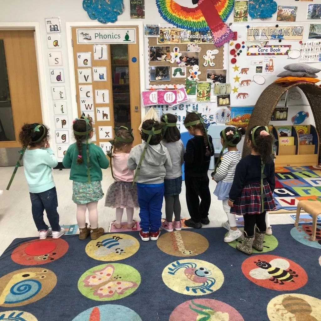 Teacher with students on colourful floor mat